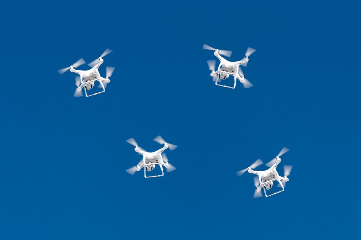 A drone swarm flying in a blue sky