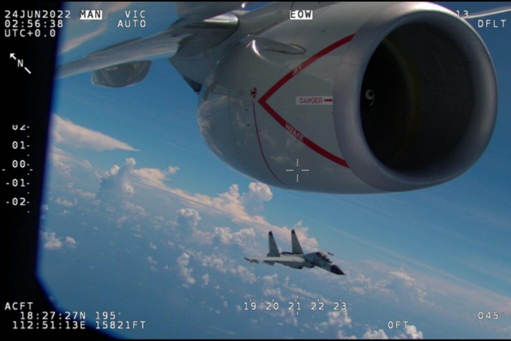 A Chinese fighter flying close to the nacelle of a US aircraft