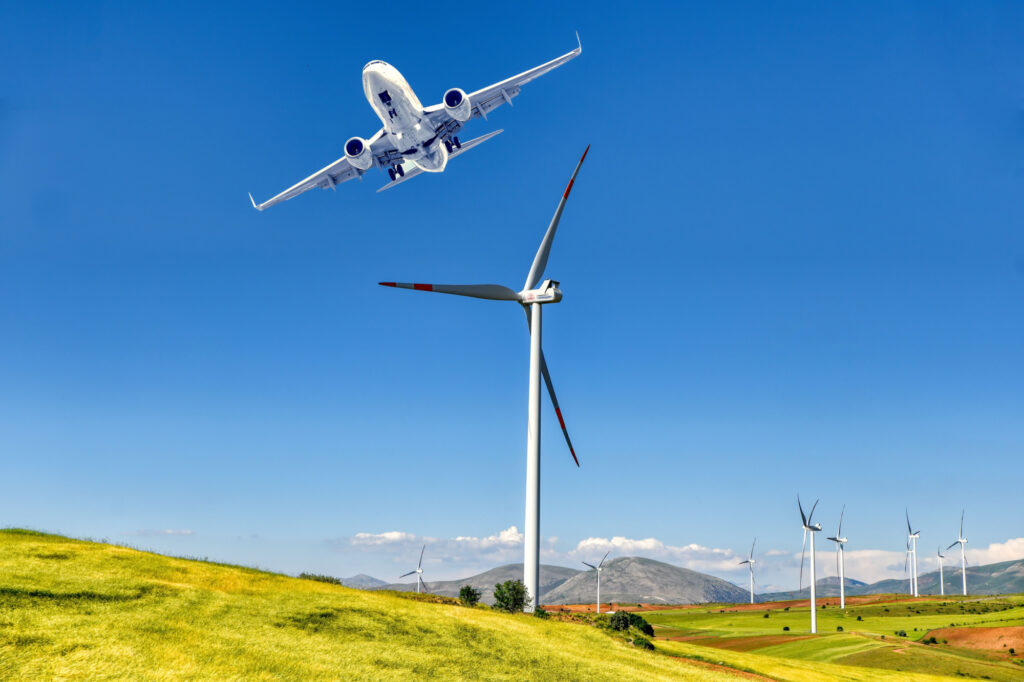 An aircraft flying by a wind turbine