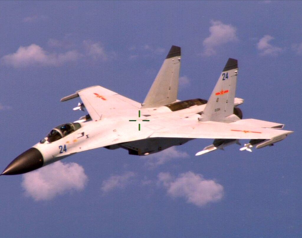 140819-N-ZZ999-113 WASHINGTON (Aug. 19, 2014) An armed Chinese fighter jet flies near a U.S. Navy P-8 Poseidon patrol aircraft over the South China Sea about 135 miles east of Hainan Island in international airspace. (U.S. Navy Photo/Released)