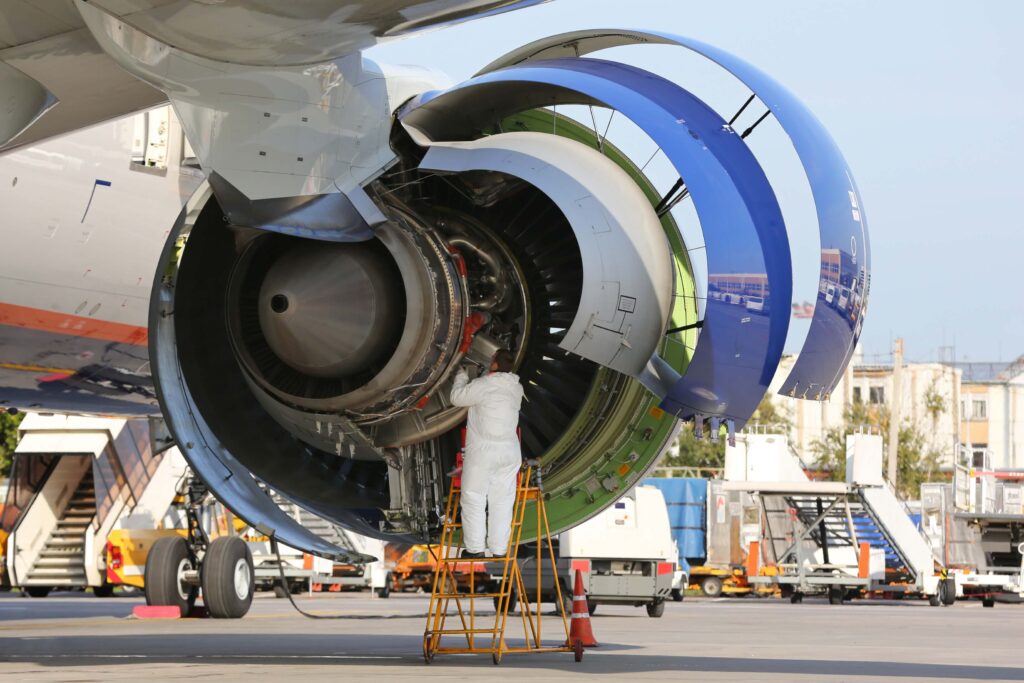 Technician checking engine of civil airliner.