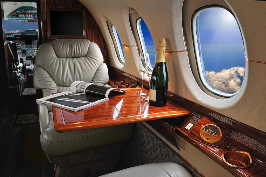 luxury interior in the modern business jet and sunlight at the windowsky and clouds through the porthole