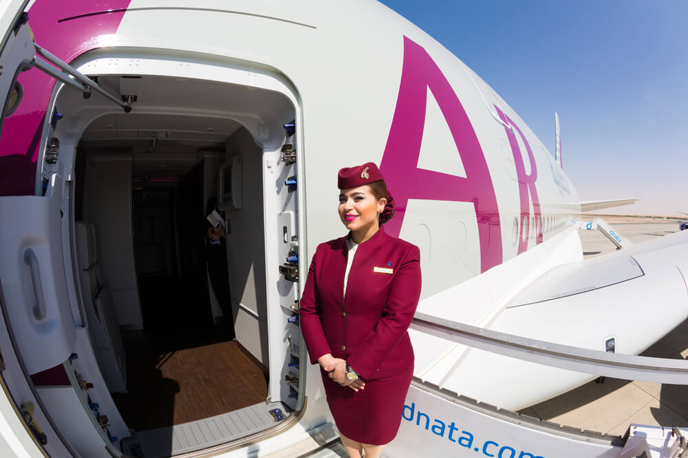 qatar_airways_flight_attendant_welcoming_passengers_on_board_an_airbus_a380.jpg