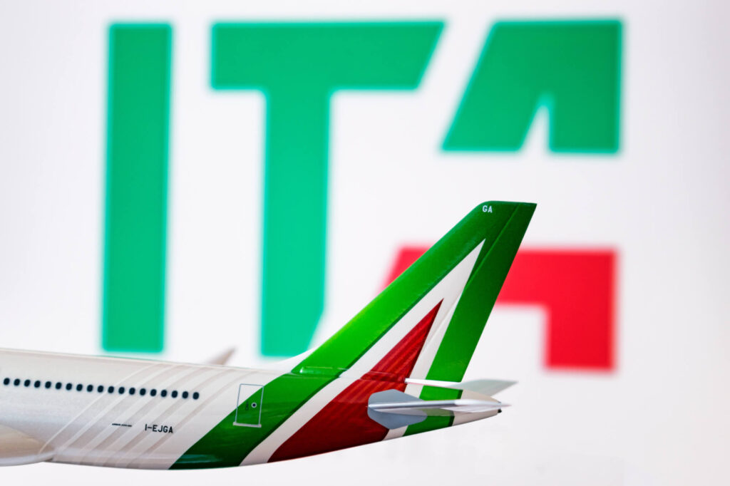 the_ita_logo_is_seen_against_an_alitalia_plane_model.jpg