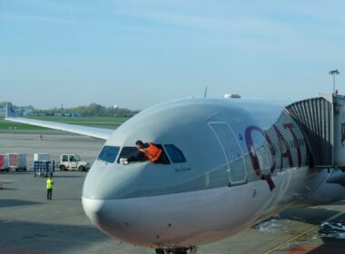 worker_is_cleaning_qatar_airways_plane_front_window_before_departure.jpg